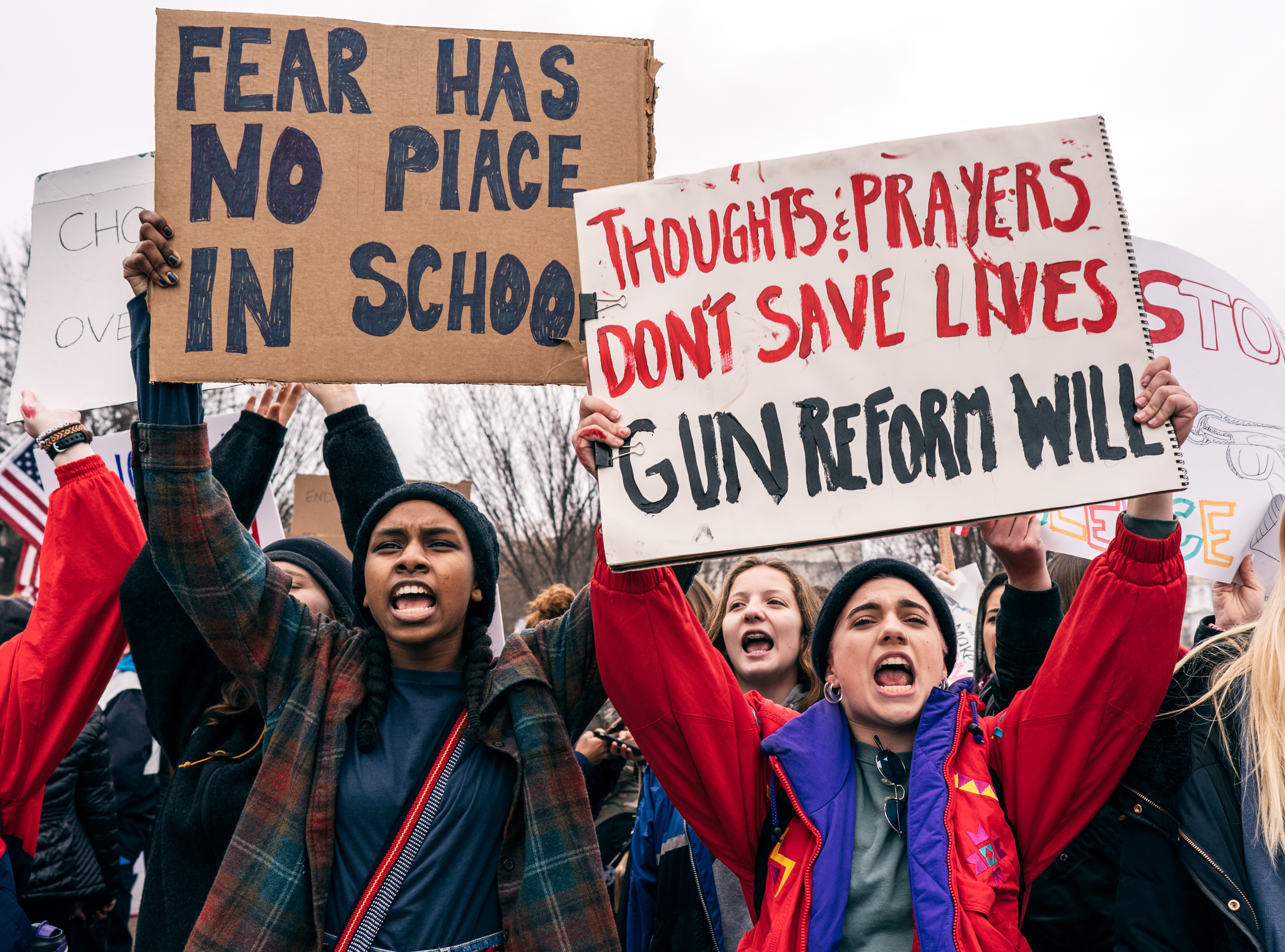 Student Protestors Holding Sign "Thoughts and Prayers Don't Save Lives