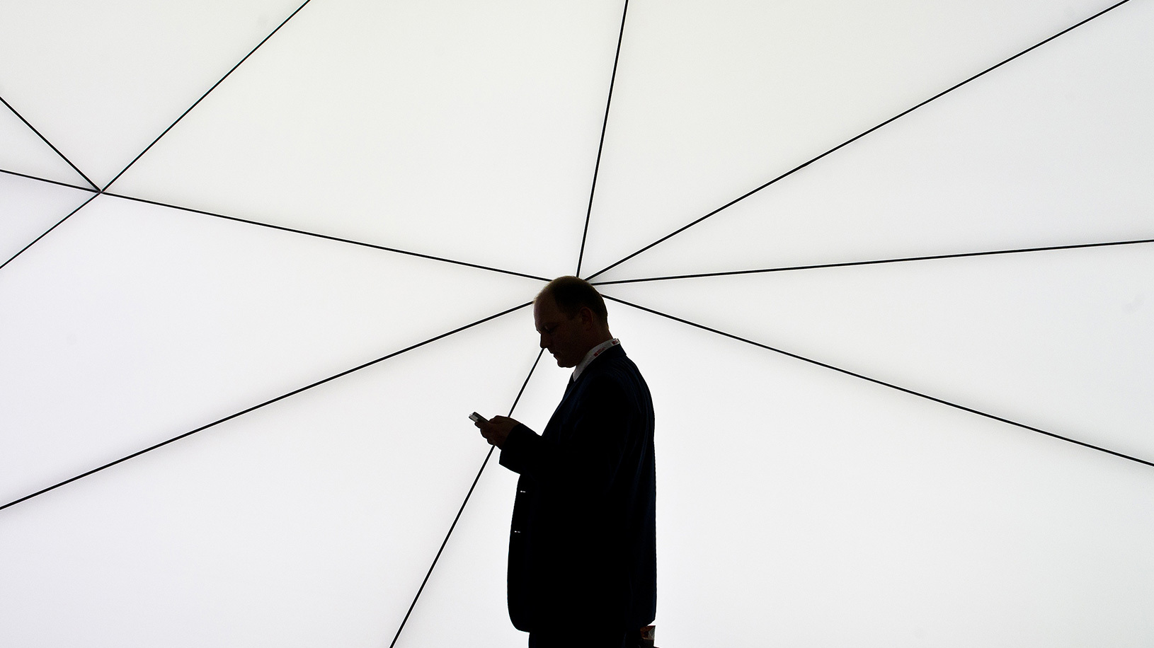 Individual looking at phone in silhouette