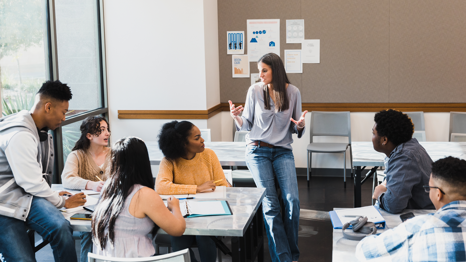 Female teacher leads group discussion in classroom