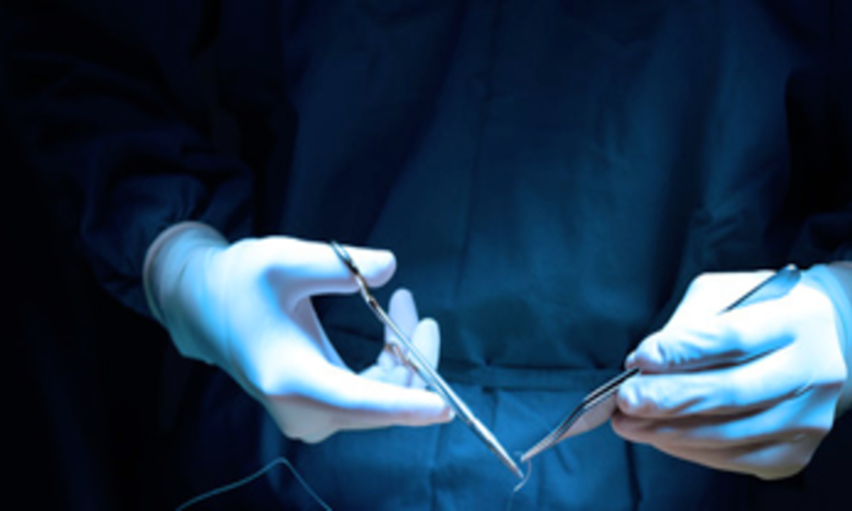 Gloved hands in operating room