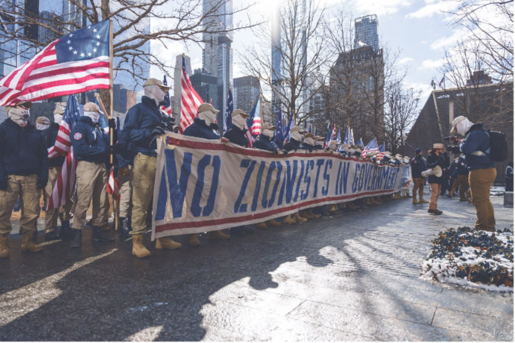 Patriot Front members stand near the National 9/11 Memorial & Museum with a large banner reading: “No Zionists in Government.” Group leader Thomas Rousseau stated the demonstration was to combat “foreign influences” in the U.S. government, making direct reference to the Israel-Hamas War. 