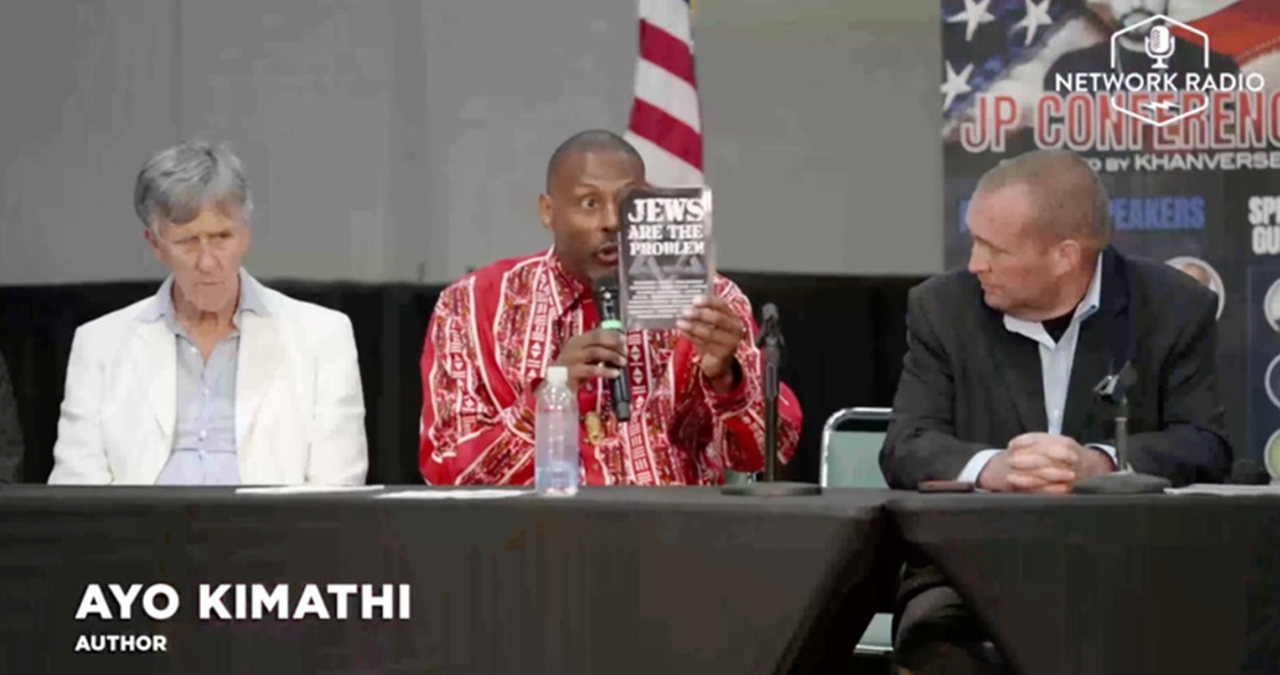 Ayo Kimathi promotes his book “Jews Are the Problem” during a panel at the JP Conference, 6/30/2024. Source: Rumble