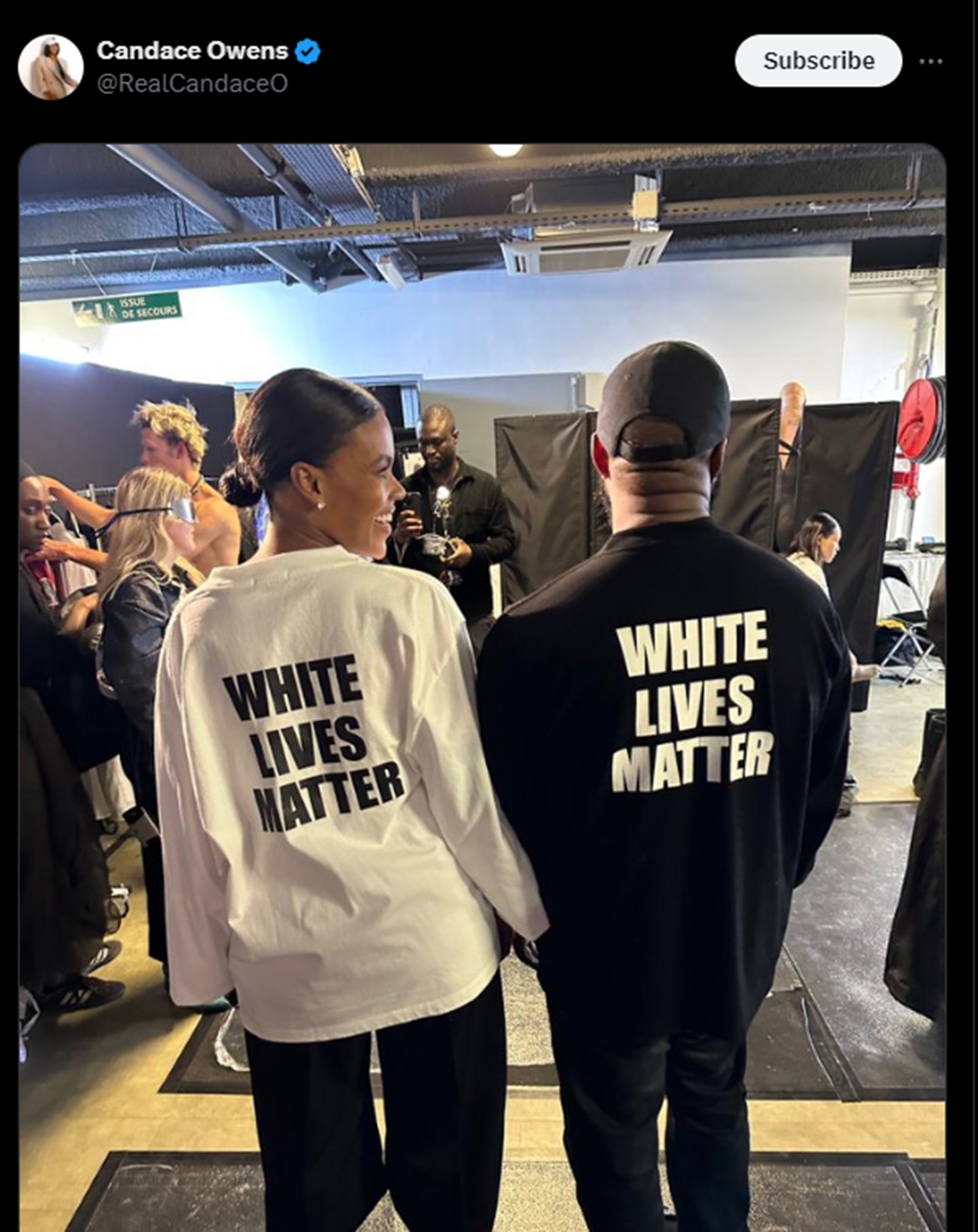 A screenshot from a tweet with an image showing Candace Owens and Kanye West wearing "White Lives Matter" shirts at a fashion show in Paris, October 2022.