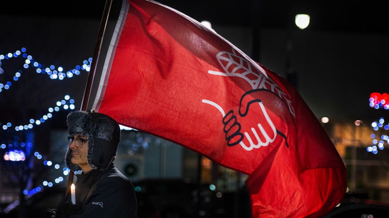 A man holds a Democratic Socialist of America flag at a vigil in Wilkes-Barre, Pennsylvania, November 20, 2022. (Aimee Dilger/SOPA Images/LightRocket via Getty Images)