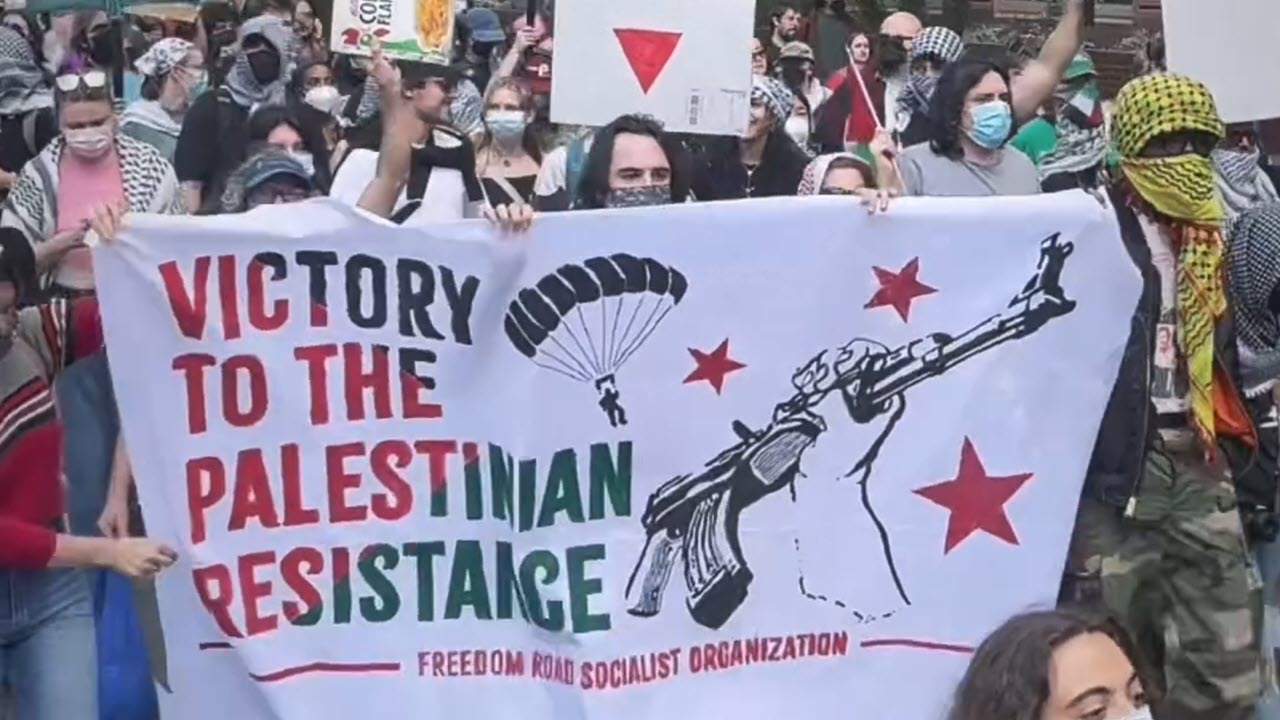 Protesters on the campus of Drexel University in Philadelphia, PA, celebrate Hamas’s October 7, 2023, attack on Israel one year later by carrying a banner that reads “Victory to the Palestinian Resistance” alongside paraglider and weapons imagery.