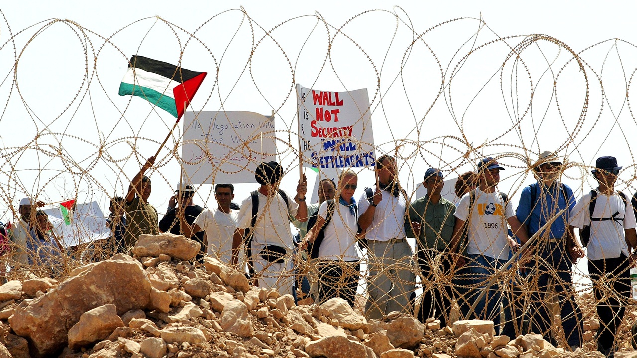 Palestinians and activists from the International Solidarity Movement (ISM) protest against Israel's security fence on August 15, 2003 at the West Bank Palestinian village of Khirbet Ras Atira. (David Silverman/Getty Images)