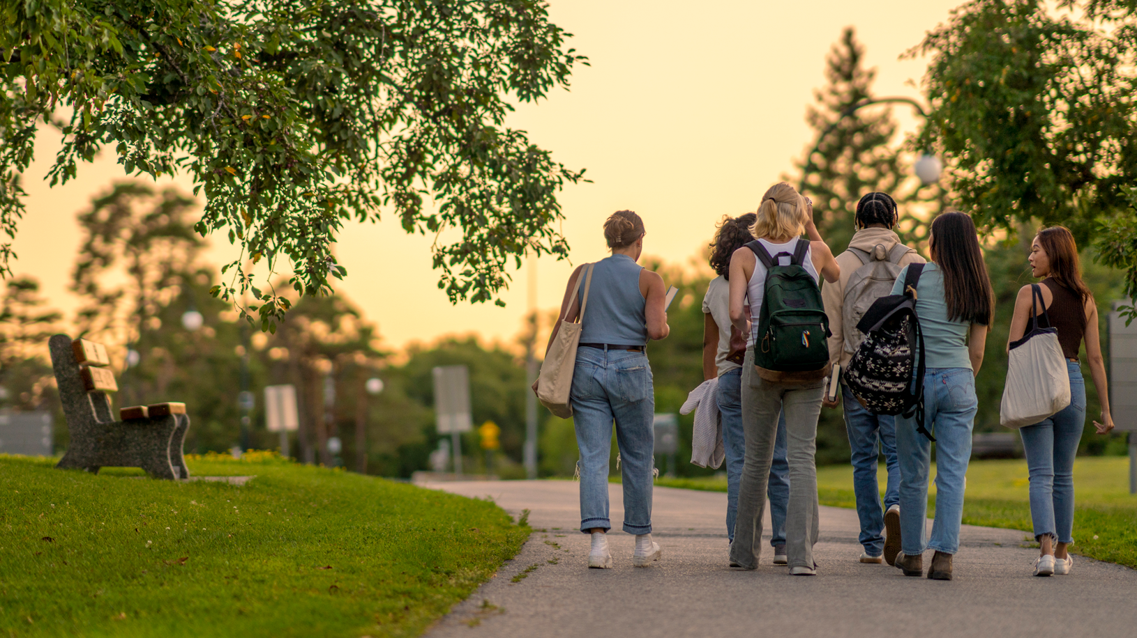 Rearview of university students walking outside on campus