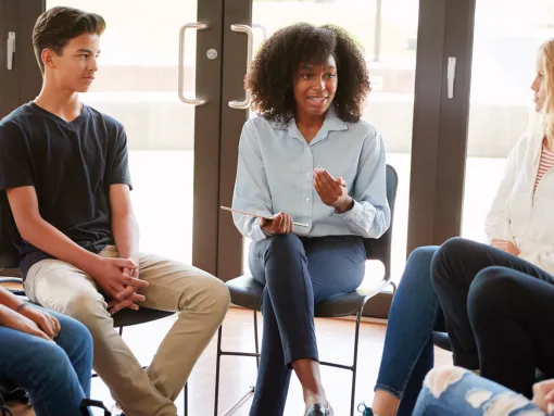 Female Tutor Leading Discussion Group Amongst High School Pupils