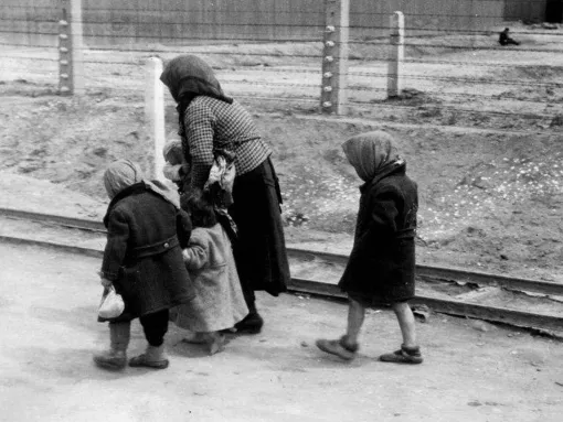 Old woman and children walking in Auschwitz-Birkenau